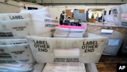 Election workers scan mail-in and absentee ballots for the 2020 general election in the United States at West Chester University, Wednesday, Nov. 4, 2020, in West Chester, Pa. (AP Photo/Matt Slocum)