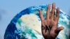 A hand of a protester reads "pay" amid calls for reparations for loss and damage at the COP27 U.N. Climate Summit, in Sharm el-Sheikh, Egypt, Nov. 18, 2022.