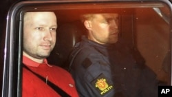 Norwegian Anders Behring Breivik (L), the man accused of a killing spree and bomb attack in Norway, sits in the rear of a vehicle as he is transported in a police convoy as he is leaving the courthouse in Oslo July 25, 2011