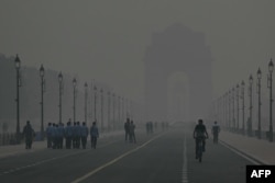 Orang-orang berjalan dalam kondisi berasap di Gerbang India di New Delhi pada 31 Oktober 2023. (Foto: Arun SANKAR/AFP)