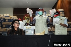 Deputi Komisi Pemberantasan Korupsi (KPK) Basariah Panjaitan (kiri) bersama petugas KPK menunjukkan tumpukan uang miliaran rupiah yang disita dari kantor seorang anggota DPR, 28 Maret 2019. (Foto: Mamat/AFP)