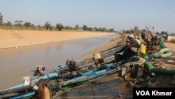 កសិករមួយចំនួននាំគ្នាបូមទឹកពីប្រឡាយមេមួយក្នុងស្រុកបាក់ចិញ្ជៀន ខេត្តពោធិ៍សាត់ ដើម្បីដាក់ស្រែរបស់ពួកគេ ។ (ស៊ុន ណារិន/វីអូអេ)
