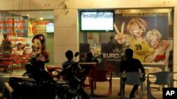 រូបឯកសារ៖ មនុស្ស​កំពុង​មើល​ការប្រកួត​បាល់ទាត់ខណៈដែល​មានការ​ភ្នាល់​បាល់​នៅ​ទីក្រុង​ប៉ោយប៉ែត​ប្រទេស​កម្ពុជា​កាលពីថ្ងៃទី​០៨ ធ្នូ ឆ្នាំ២០១២។