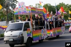 Para pendukung pernikahan sesama jenis mengibarkan bendera di gedung pemerintah di Bangkok, Thailand, Selasa, 18 Juni 2024, merayakan diloloskannya RUU kesetaraan dalam pernikahan. (AP/Sakchai Lalit)