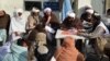 FILE - Afghan refugees deported from Pakistan wait to receive food aid by Red Cross Society in Kandahar on Jan. 24, 2024