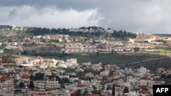 Slika snimljena u selu Turmus Ayya u blizini grada Ramallah prikazuje obližnje izraelsko naselje Shilo u pozadini, na okupiranoj Zapadnoj obali 18. februara 2024. godine.