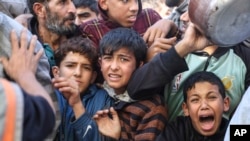 Palestinyen fe la ke pou resevwa manje nan Rafah, Gaza, 30 Novanm 2023.