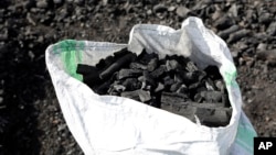 A sack of charcoal is filled in Gulu, Uganda on May 27, 2023. Uganda's population explosion has heightened the need for cheap plant-based energy sources, especially charcoal.