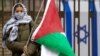 Demonstrantkinja sa palestinskom zastavom ispred ambasade Izraela u Vašingtonu, decembar 2023. (Foto: Reuters/Kevin Lamarque)