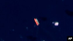 FILE - In this satellite photo provided by Planet Labs PBC, vessels identified as the Virgo, left, and the Suez Rajan — now the St. Nikolas — by the advocacy group United Against Nuclear Iran are seen in the South China Sea on Feb. 13, 2022. 