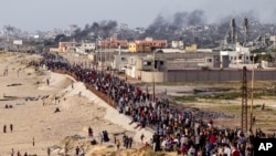 Palestinci čekaju da kamioni pomoći pređu u centralni pojas Gaze 19. maja 2024.