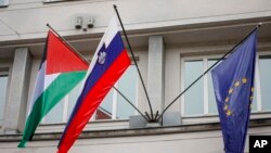 A Palestinian flag flies next to a Slovenian, center, and a European Union flag, right, at the government building in Ljubljana, Slovenia, Thursday, May 30, 2024.