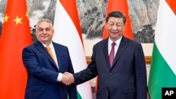 На оваа фотографија објавена од новинската агенција Xinhua, унгарскиот премиер Виктор Орбан се ракува со кинескиот претседател Шји Џјинпинг пред состанокот во Пекинг, 8 јули 2024 година