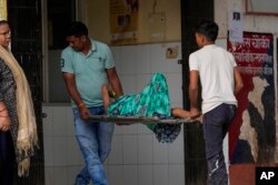 FILE - An elderly woman suffering from a heat-related ailment is brought to a government district hospital in Ballia, Uttar Pradesh state, India, June 20, 2023.
