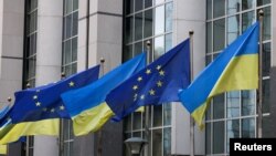 Flags of Ukraine fly in front of the EU Parliament building on the first anniversary of the Russian invasion, in Brussels, Belgium, Feb. 24, 2023. 