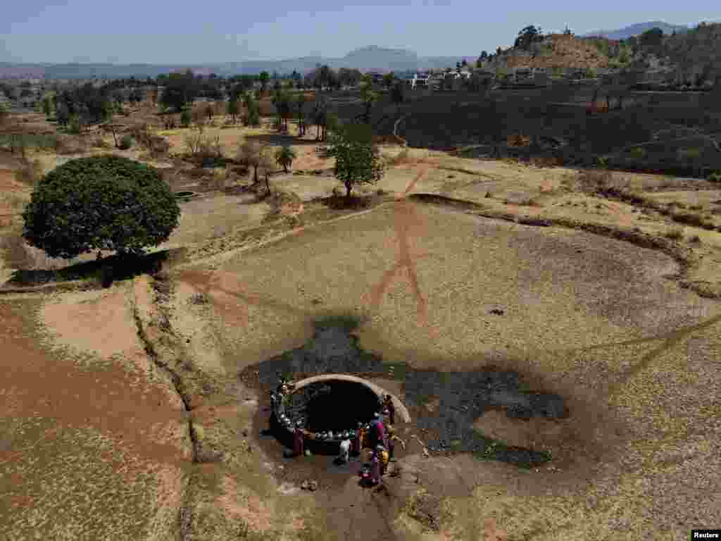 A drone view of women drawing water from a well on a hot day in Kasara, India, May 1, 2024. 