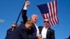 Republikanski predsjednički kandidat, bivši predsjednik Donald Trump, okružen je agentima američke tajne službe nakon pokušaja atentata na predizbornom skupu u Butleru, Pensilvanija, 13. jula 2024., na slici novinara AP-a Evana Vuccija.