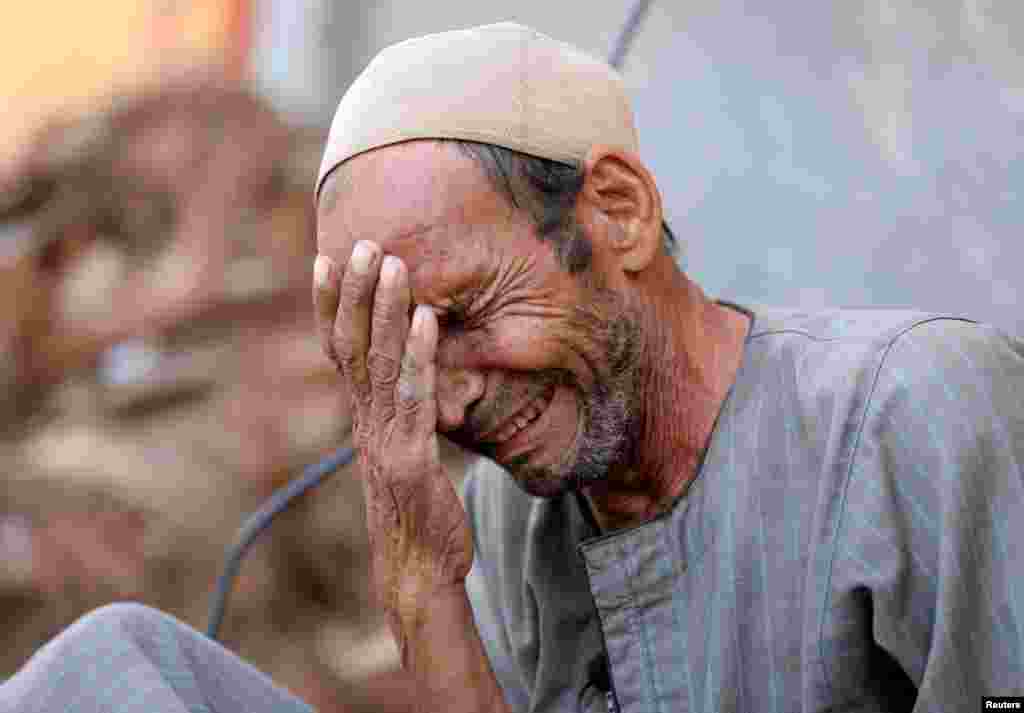 Hassan El Salheen weeps after burying the repatriated body of his son, Aly, who died along with his three cousins in Libya after Storm Daniel hit the country, at Al Sharief village in Bani Swief province, Egypt, Sept. 13, 2023.