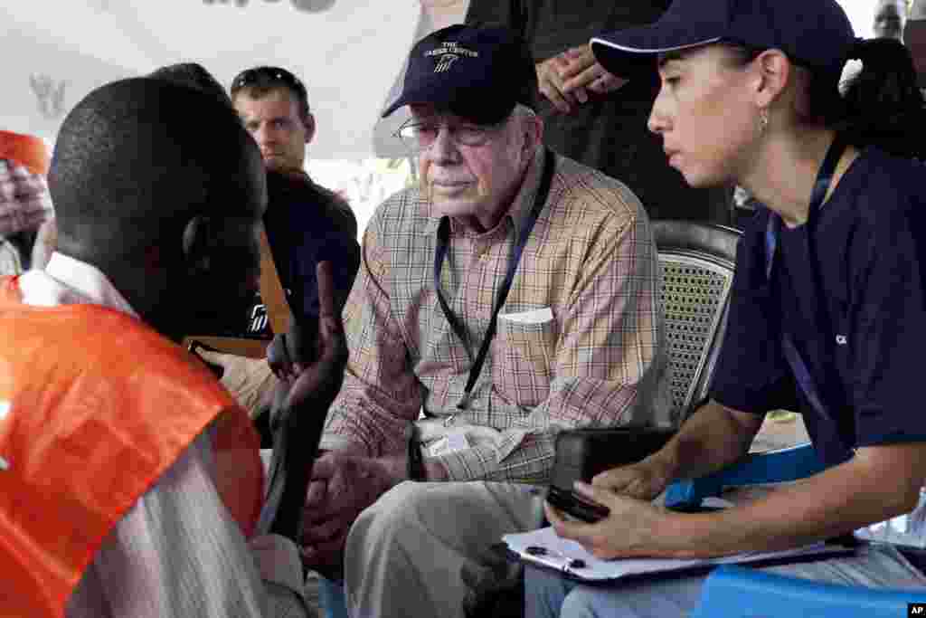 FILE - Former U.S. President Jimmy Carter speaks with a polling official at a polling station outside Juba, southern Sudan, April 13, 2010. Carter&#39;s organization, the Carter Center, deployed a team of observers for the elections. Widespread problems with voting prompted Sudanese authorities to extend the voting period from three to five days.&nbsp;