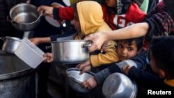 Arhiv - Palestinska djeca čekaju da prime obrok koji su pripremile humanitarne kuhinje usred nestašice hrane u Rafahu, na ugu Pojasa Gaze, 5. marta 2024.
