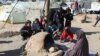 A Palestinian woman bakes bread as children sit next to her, while Gaza residents face crisis levels of hunger and soaring malnutrition, in Khan Younis in the southern Gaza Strip, Jan. 24, 2024.
