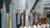 Belarusian military officers view heavy rounds on display at the Russian pavilion during the International Defense Exhibition (IDEX) at the Abu Dhabi International Exhibition Centre, Feb. 20, 2023. 