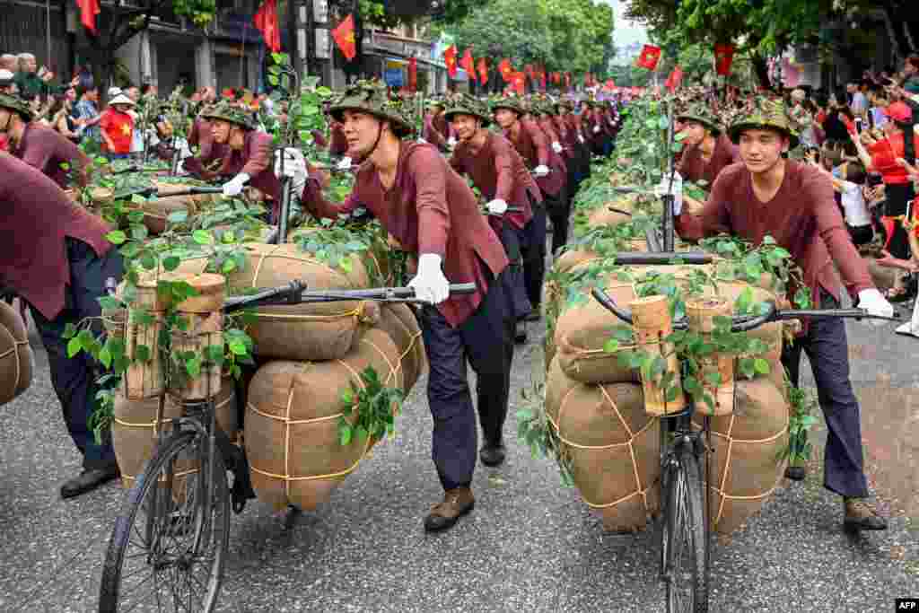 Performers walk with bicycles depicting the transportation of food and necessities to the battlefields during official celebrations of the 70th anniversary of the 1954 Dien Bien Phu victory over French colonial forces in Dien Bien Phu city, Vietnam.&nbsp;