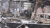 Salju turun saat petugas polisi melanjutkan operasi pencarian di sekitar pasar yang terbakar di Wajima usai gempa, prefektur Ishikawa, Jepang, 7 Januari 2024. (Foto: Kyodo via AP)