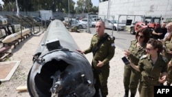 Portparol izraelske vojske kontraadmiral Daniel Hagari i drugi pripadnici izraelske vojske stoje pored iranske balističke rakete koja je pala u Izrael tokom vikenda.
