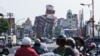 Warga lokal berkendara melewati sejumlah bangunan yang rusak akibat gempa di Hualien, Taiwan, pada 4 April 2024. (Foto: AFP/Sam Yeh)