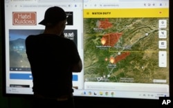 A Ruidoso resident checks a map on a screen while spending the night at a shelter in Roswell, New Mexico, June 18, 2024.