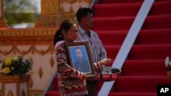 សាច់ញាតិ​កាន់​រូបថត​របស់​យោធិន​ម្នាក់​ដែល​បាន​ស្លាប់​ក្នុង​អំឡុង​ហេតុការណ៍​ផ្ទះ​គ្រាប់​មួយ​នៅ​ទី​បញ្ជាការ​ដ្ឋាន​យោធ​ភូមិភាគ​ទី៣ ក្នុង​ខេត្ត​កំពង់​ស្ពឺ​ ដែល​បណ្តាល​ឱ្យ​យោធិន​២០​នាក់​ស្លាប់​បាត់​បង់​ជីវិត​​ ថ្ងៃទី ២៨ ខែមេសា ឆ្នាំ២០២៤។​ (AKP via AP)
