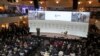 Pictures of the war in Ukraine are seen on a screen at the Munich Security Conference in Munich, Germany, Feb. 17, 2023
