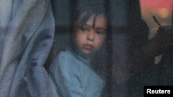 Seorang anak melihat keluar jendela bus saat warga sipil yang dievakuasi dari wilayah Kherson di Ukraina yang dikuasai oleh Rusia, tiba di sebuah stasiun kereta lokal menyusul perintah evakuasi oleh pejabat Rusia, 2 November 2022. (Foto: Alexey Pavlishak/Reuters)