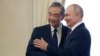 Presiden Rusia Vladimir Putin (kanan) dan Menteri Luar Negeri China Wang Yi berjabat tangan sebelum pertemuan di Istana Konstantin di St. Petersburg, Rusia, Rabu, 20 September 2023. (Mikhail Metzel, Sputnik, Kremlin Pool Photo via AP)