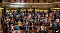 Spain's Prime Minister Pedro Sanchez, foreground left, applauds after the approval to an amnesty law at the Spanish parliament's lower house in Madrid, May 30, 2024. 