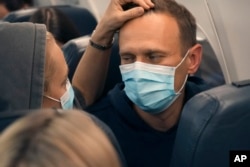FILE - Alexey Navalny dan istrinya, Yulia, duduk di pesawat dalam penerbangan ke Moskow dari Berlin, 17 Januari 2021, setelah pulih di Jerman dari keracunan agen saraf Nofichok, pada Agustus 2020.
