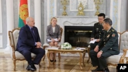 In this handout photo released by Belarusian Presidential Press Office, Belarusian President Alexander Lukashenko, left, and China's Defense Minister Gen. Li Shangfu, right, speak during their talks in Minsk, Belarus, Aug. 17, 2023.