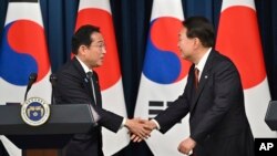 윤석열 한국 대통령(오른쪽)과 기시다 후미오 일본 총리가 지난해 5월 서울에서 열린 정상회담에서 악수하고 있다.