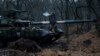 A Ukrainian serviceman smokes a cigarette while standing on top of a tank near Bakhmut, Ukraine, March 8, 2023. 