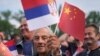 A man waves Chinese and Serbian flags as he waits for the arrival of Chinese President Xi Jinping and his Serbian counterpart, Aleksandar Vucic, outside the Serbia Palace in Belgrade, May 8, 2024.