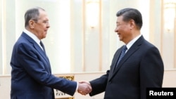 ប្រធានាធិបតី​ចិន​លោក Xi Jinping ចាប់ដៃ​ជាមួយ​នាយករដ្ឋមន្ត្រី​ការបរទេស​រុស្ស៊ី​លោក Sergey Lavrov អំឡុង​កិច្ច​ប្រជុំ​របស់​ពួកគេ​នៅ​ក្នុង​ទីក្រុងប៉េកាំង​ប្រទេស​ចិន​កាលពី​ថ្ងៃទិ​០៩ មេសា ឆ្នាំ២០២៤។(Russian Foreign Ministry/Handout via Reuters)
