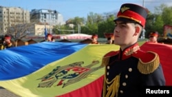 Članovi počasne garde drže moldavsku zastavu tokom ceremonije obilježavanja Dana državne zastave u Kišinjevu, Moldavija, 27. april 2023. (Foto: REUTERS/Vladislav Culiomza)