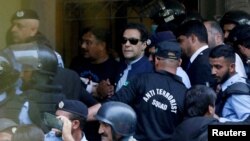 FILE - Security officers escort Pakistani former Prime Minister Imran Khan as he appears in Islamabad High Court, in Islamabad, Pakistan, May 12, 2023.