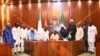 Shugaba Bola Tinubu a zagaye da wasu jami'in gwamnatinsa yayin da ya rattaba hanu akan dokar rancen dalibai.