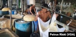 Pekerja menyaring tahu saat proses memasak kedelai menjadi tahu (foto Petrus Riski-VOA)