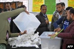 Election officials prepare to count ballot papers at a polling booth in Dhaka on Jan. 7, 2024.