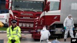 FILE - Forensic police officers attend the scene where a truck was found with a large number of dead bodies, in Grays, England, Oct. 23, 2019. 