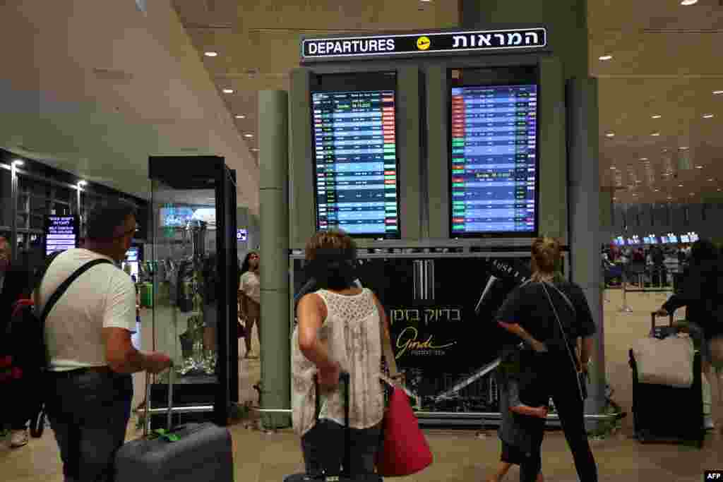 Passengers look at a departure board at Ben Gurion Airport near Tel Aviv, Israel, on Oct. 7, 2023, as flights are canceled because of the Hamas surprise attacks.