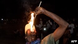 Un homme exécute une acrobatie avec du feu lors du festival du Kankurang à Janjanbureh, le 27 janvier 2024. (Photo MUHAMADOU BITTAYE / AFP)